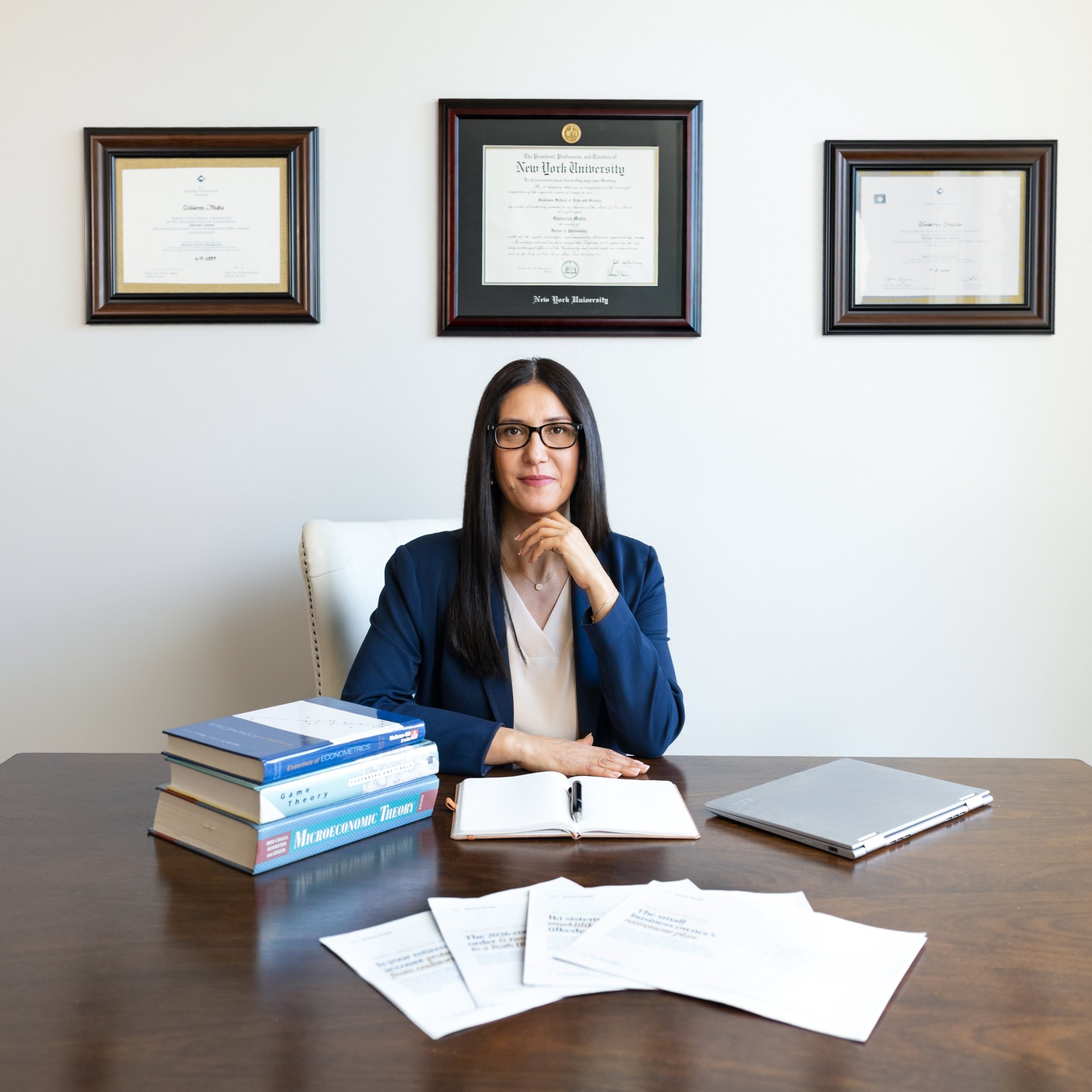 Dr. Gülseren Mutlu at her desk, her diplomas on the wall behind her